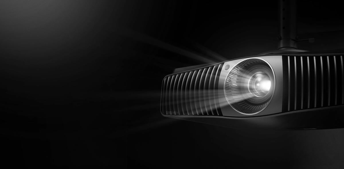 Beamer mit eingeschaltetem Licht in dunklem Raum.