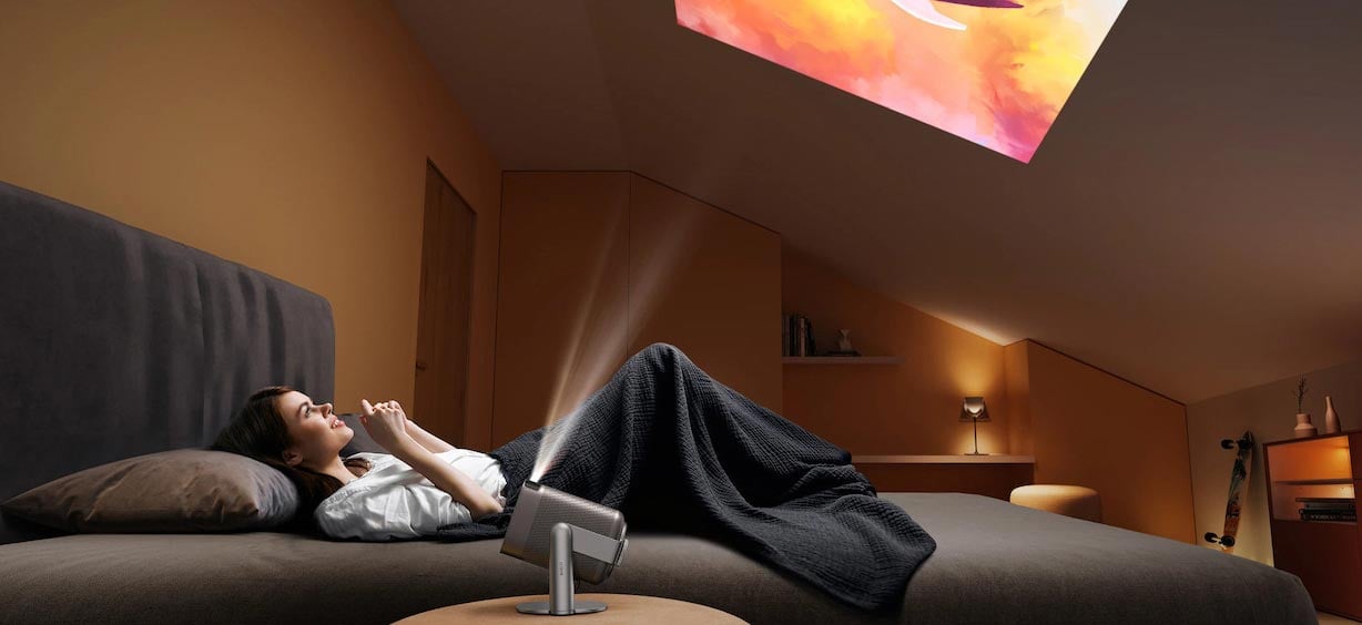 Frau im Bett mit Beamer-Projektion.